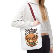 Person holding a tote bag with a cartoon Highland cow and 'Highland Cuteness' text.