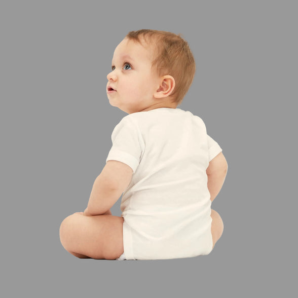 Baby wearing a white onesie on a white background