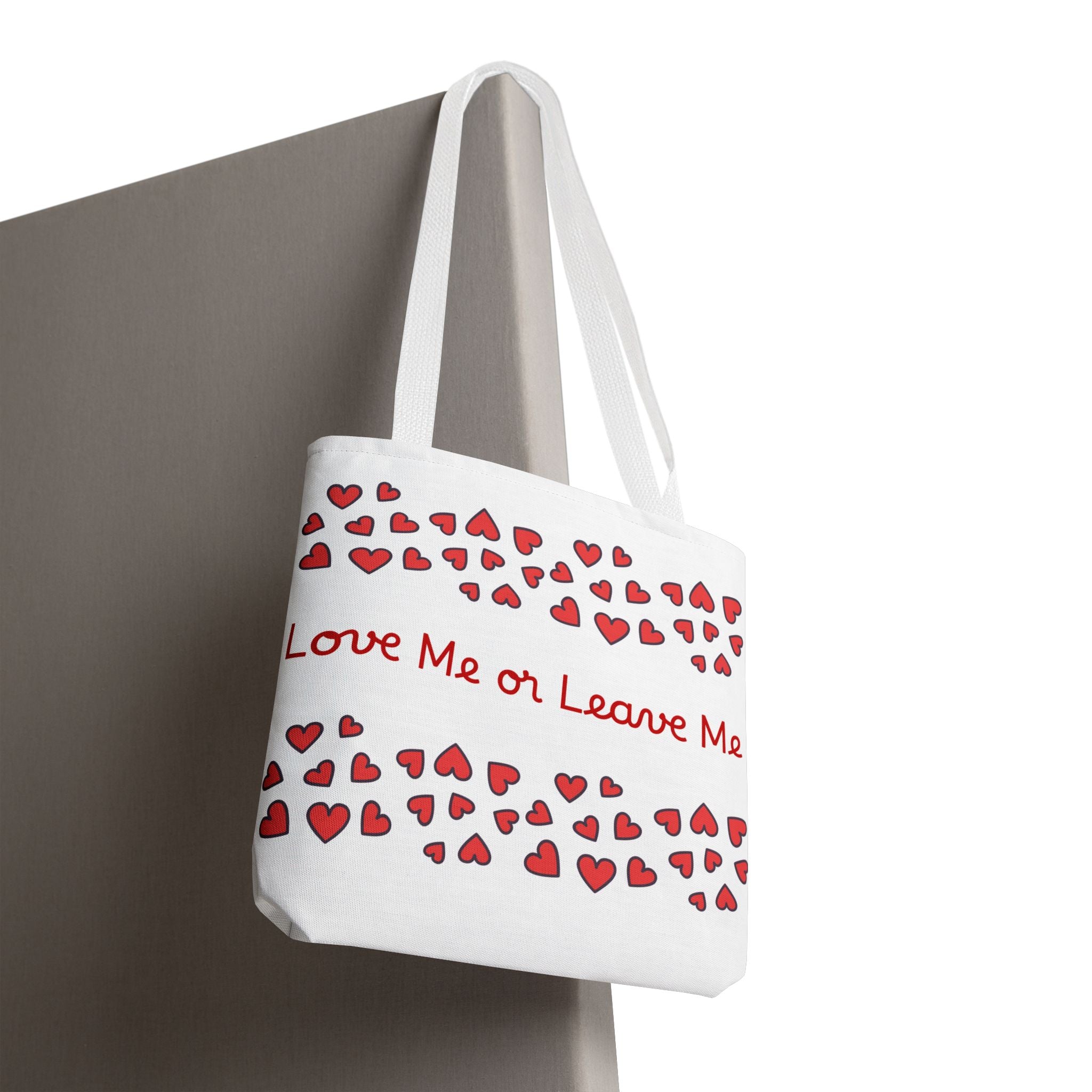 White tote bag with red heart patterns and text 'Love Me or Leave Me' on a white background