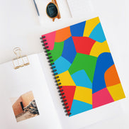 Colorful geometric notebook on a white surface with a photo and clip.