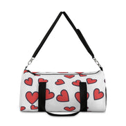 White duffel bag with red heart patterns and black straps on a white background