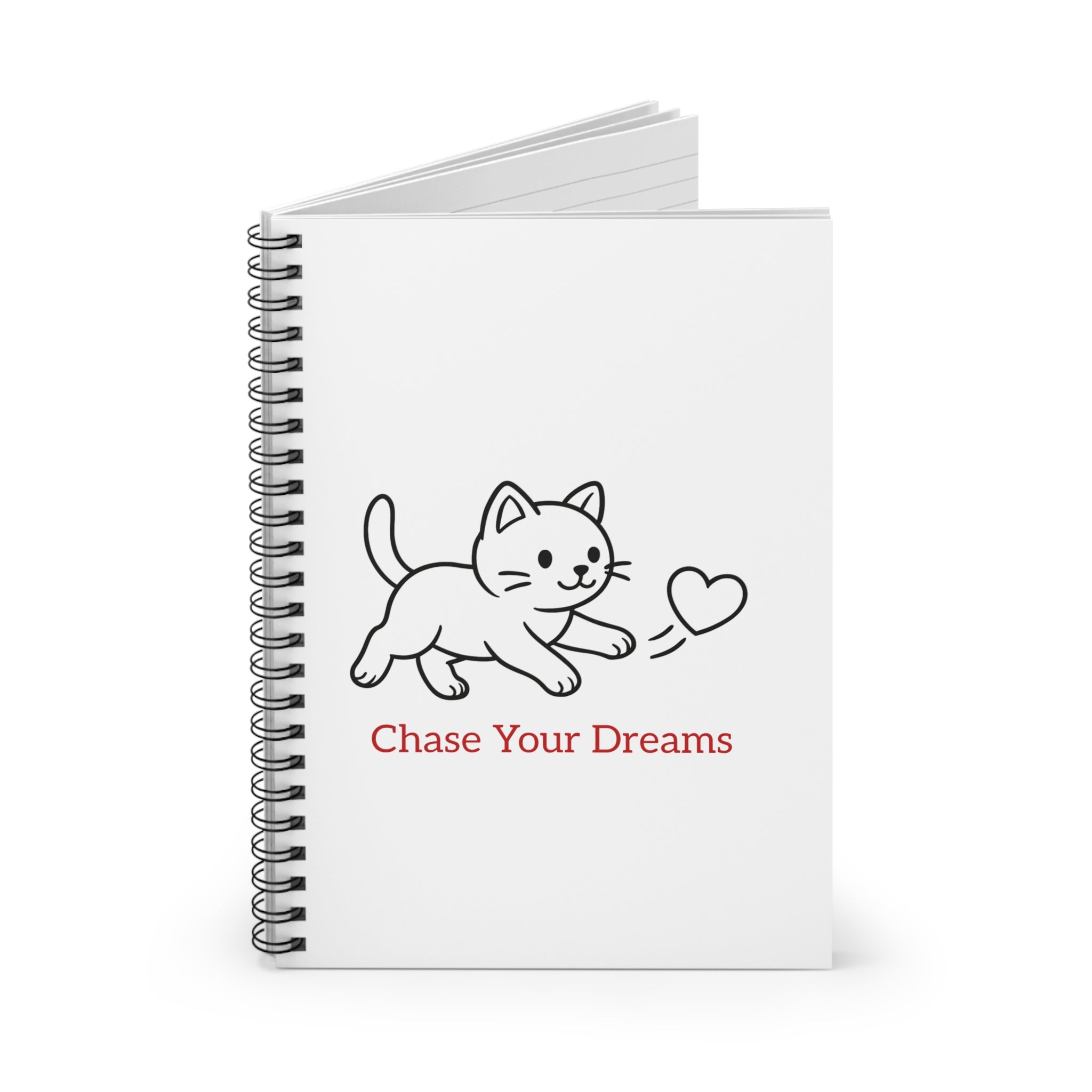 cat on white notebook with chase your dreams text.