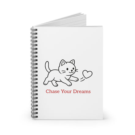 cat on white notebook with chase your dreams text.