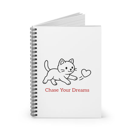 cat on white notebook with chase your dreams text.