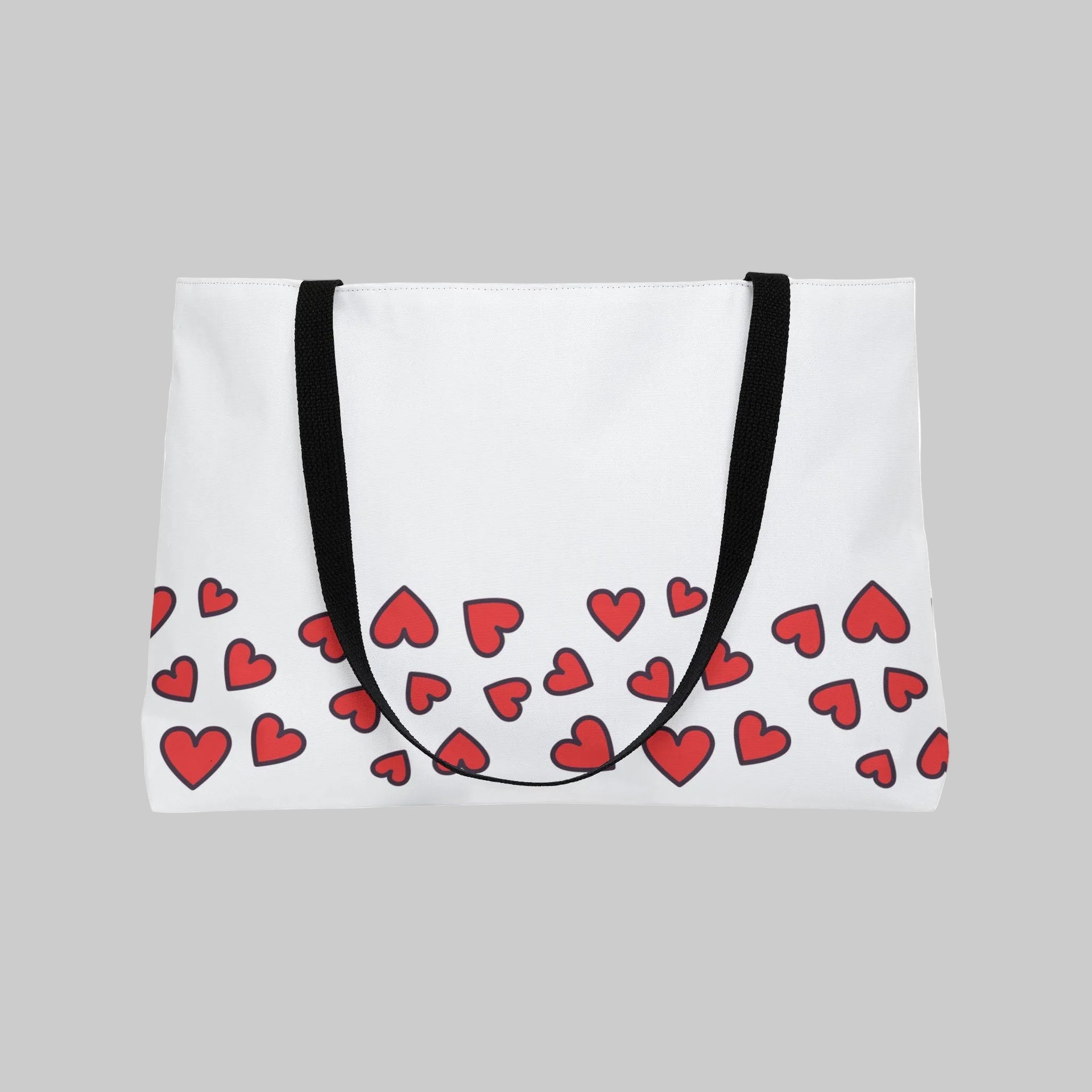 White tote bag with red heart pattern and black straps on a white background