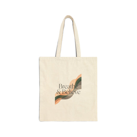 Beige tote bag with 'Breathe & Believe' text and leaf design on a white background