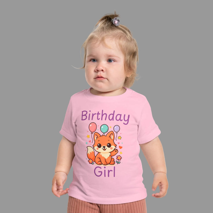 Birthday Girl baby t-shirt with cute fox and colorful balloons first birthday design. Child wearing a pink 'Birthday Girl' t-shirt with a fox design on a white background