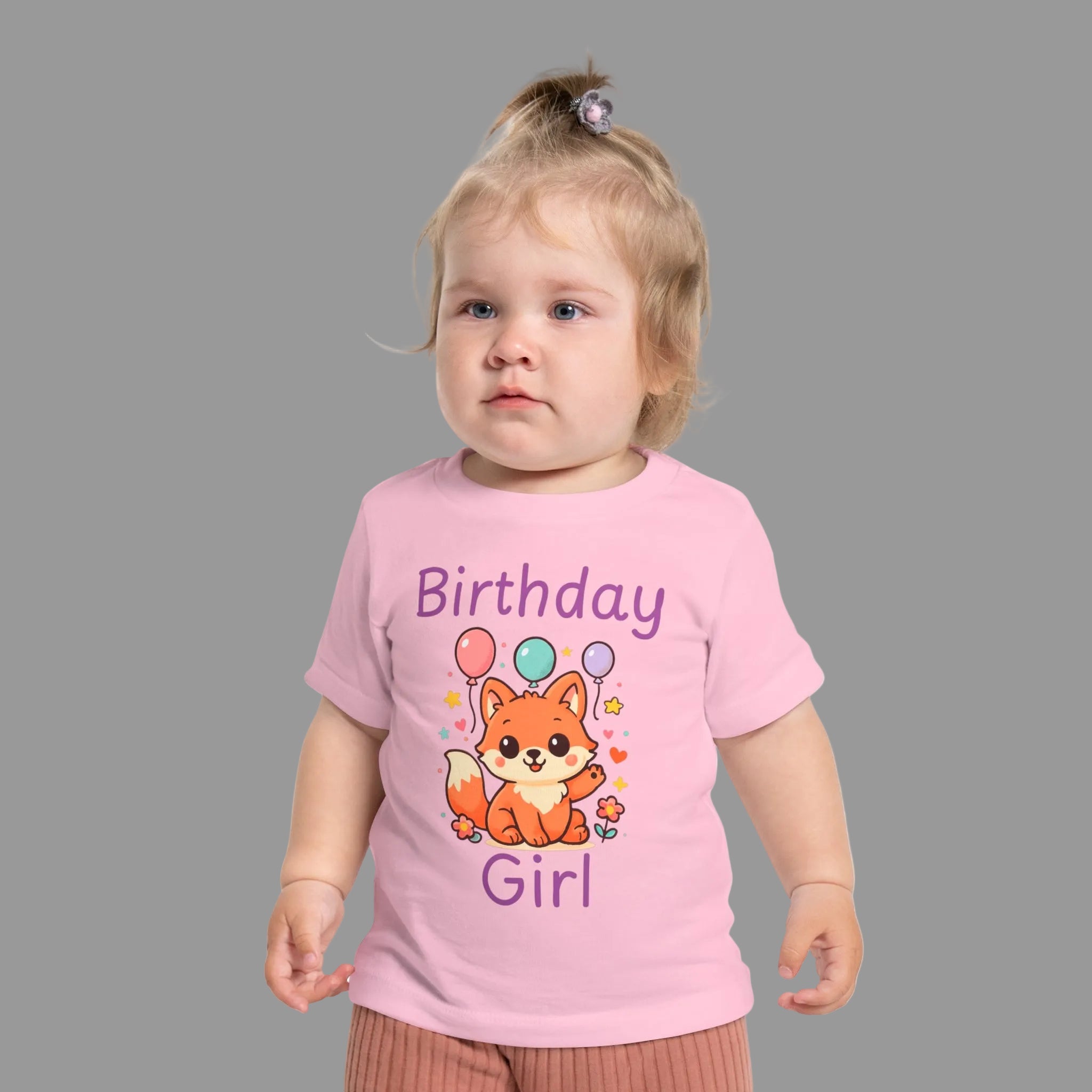 Birthday Girl baby t-shirt with cute fox and colorful balloons first birthday design. Child wearing a pink 'Birthday Girl' t-shirt with a fox design on a white background