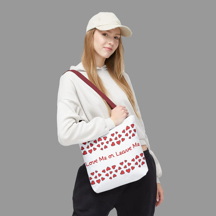 Person holding a white bag with red heart patterns and text on a white background