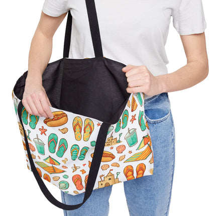 Person holding a tote bag with a colorful pattern of flip-flops, hot dogs, and other items.