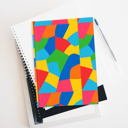 Colorful geometric-patterned notebook on a white surface with a pen.