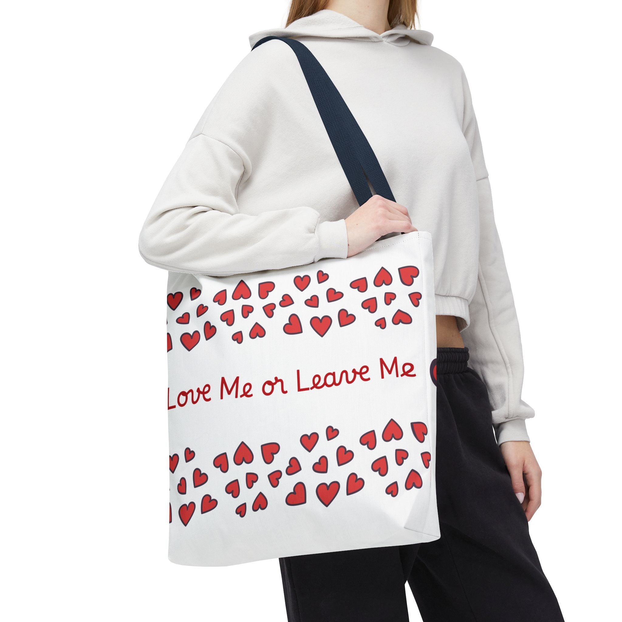Person holding a tote bag with red hearts and text on a white background
