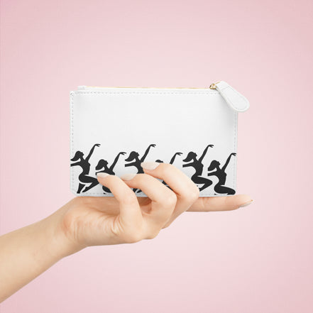 a hand holding a white bag with black silhouettes of dancers
