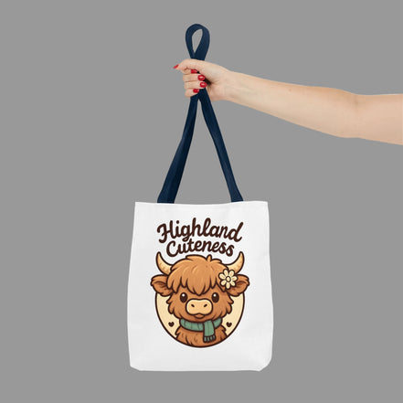Highland Cuteness tote bag with adorable Highland cow graphic design. Tote bag with a cartoon highland cow and 'Highland Cuteness' text, held by a hand.