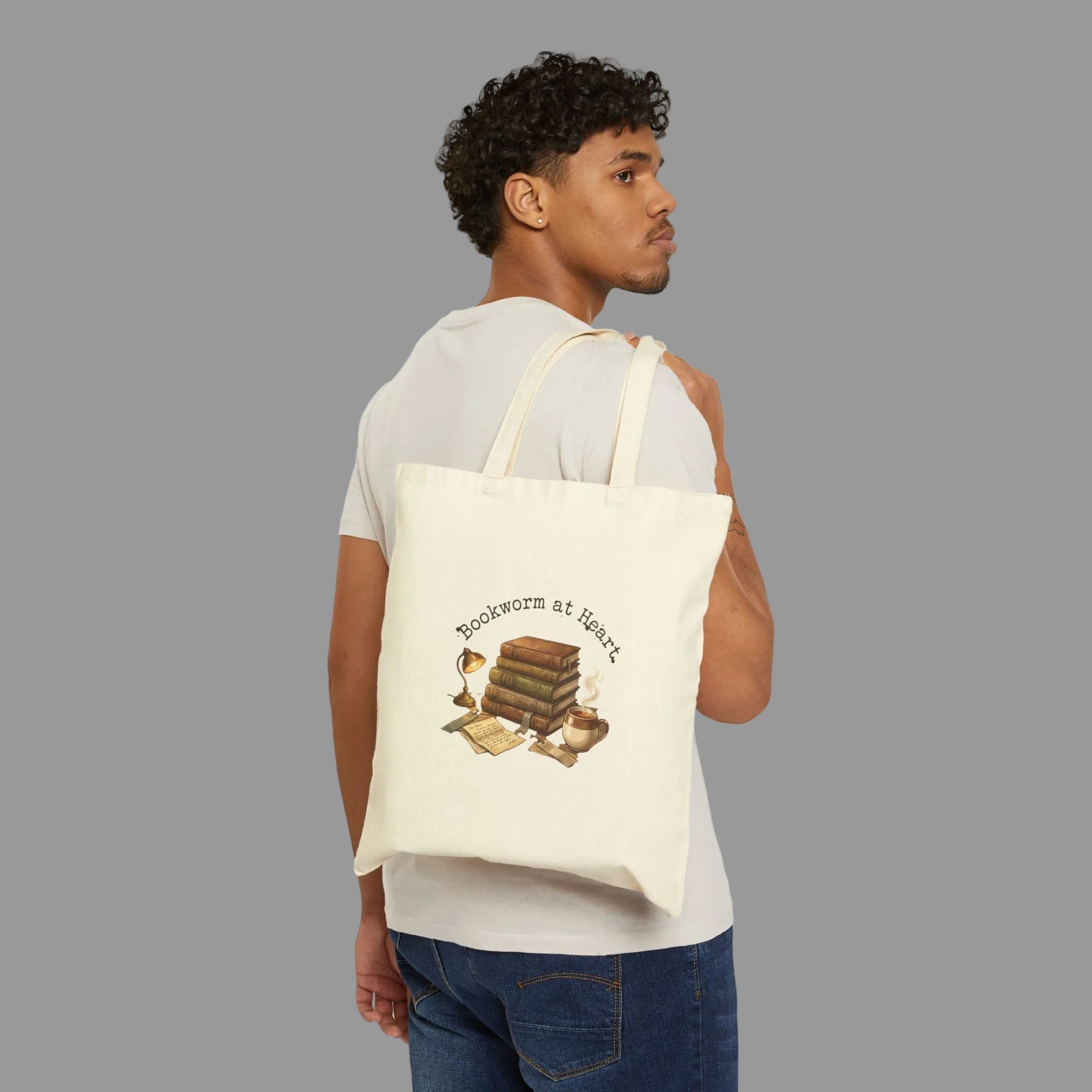 Man carrying a tote bag with a book-themed design on a white background
