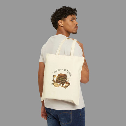 Man carrying a tote bag with a book-themed design on a white background
