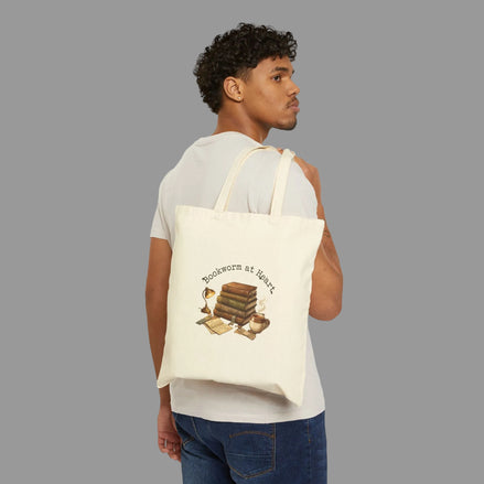 Man carrying a tote bag with a book-themed design on a white background