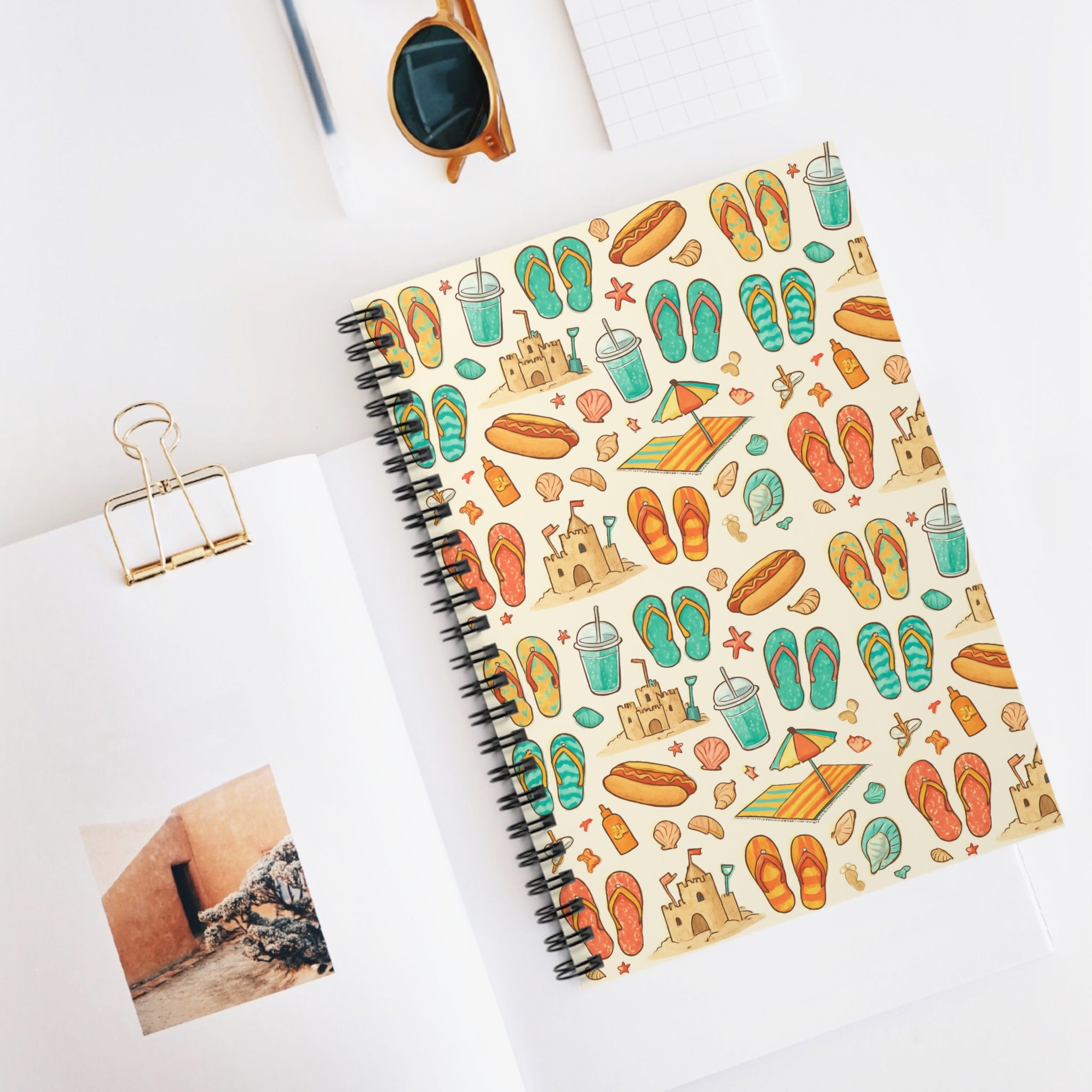 Notebook with beach-themed cover design on a white surface