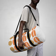 Person holding a patterned duffel bag against a plain background
