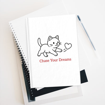 Notebook with a cat illustration and 'Chase Your Dreams' text on a white background