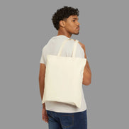 Man carrying a beige tote bag on a white background
