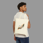 Man carrying a tote bag with 'Breathe & Believe' text and leaf design on a white background