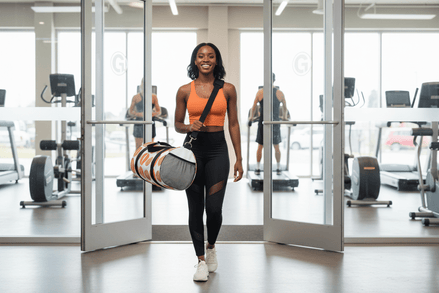 a woman leaves a gym with a highland cow designed duffel bag
